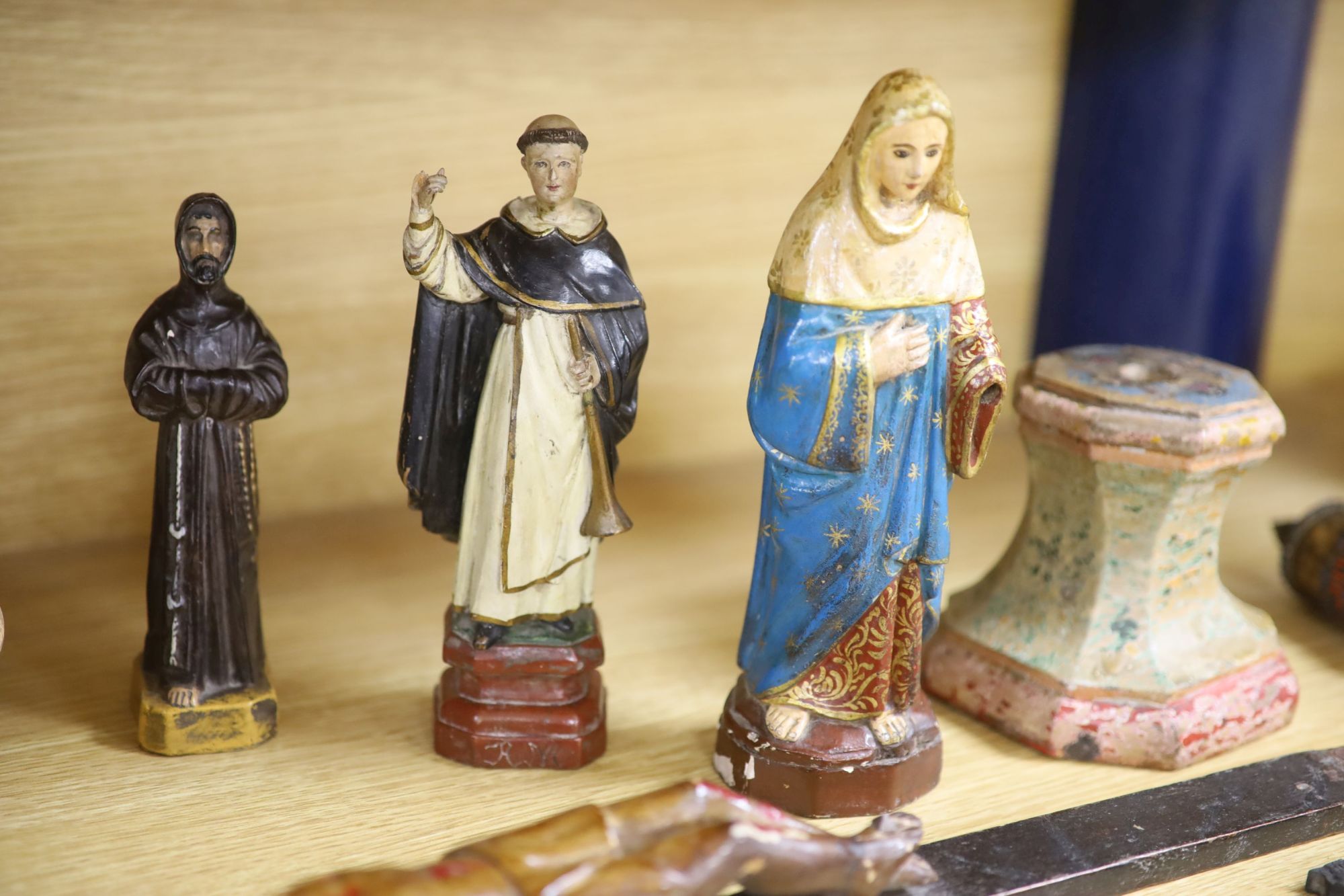 A collection of Spanish/South American carved wood or composition figures of Saints, salt box etc, tallest 30cm